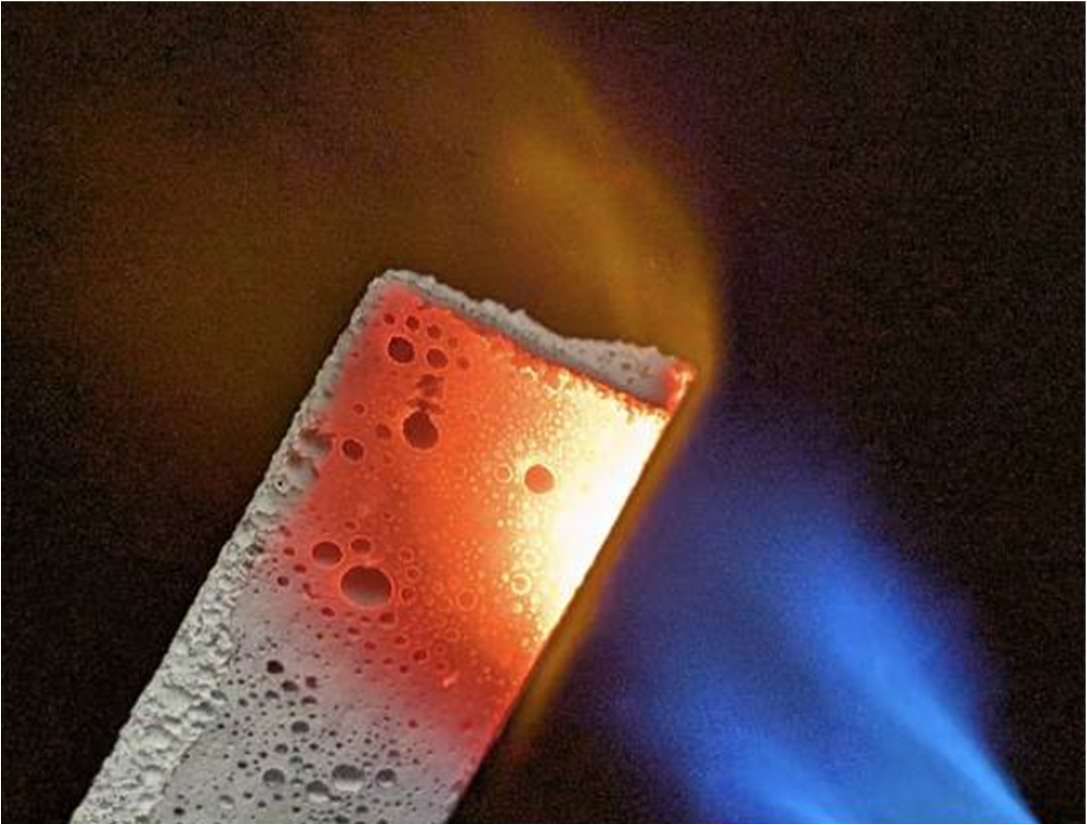 FurnaSure ceramic foam under a blue torch, glowing red-hot on one face while the opposite face stays cool